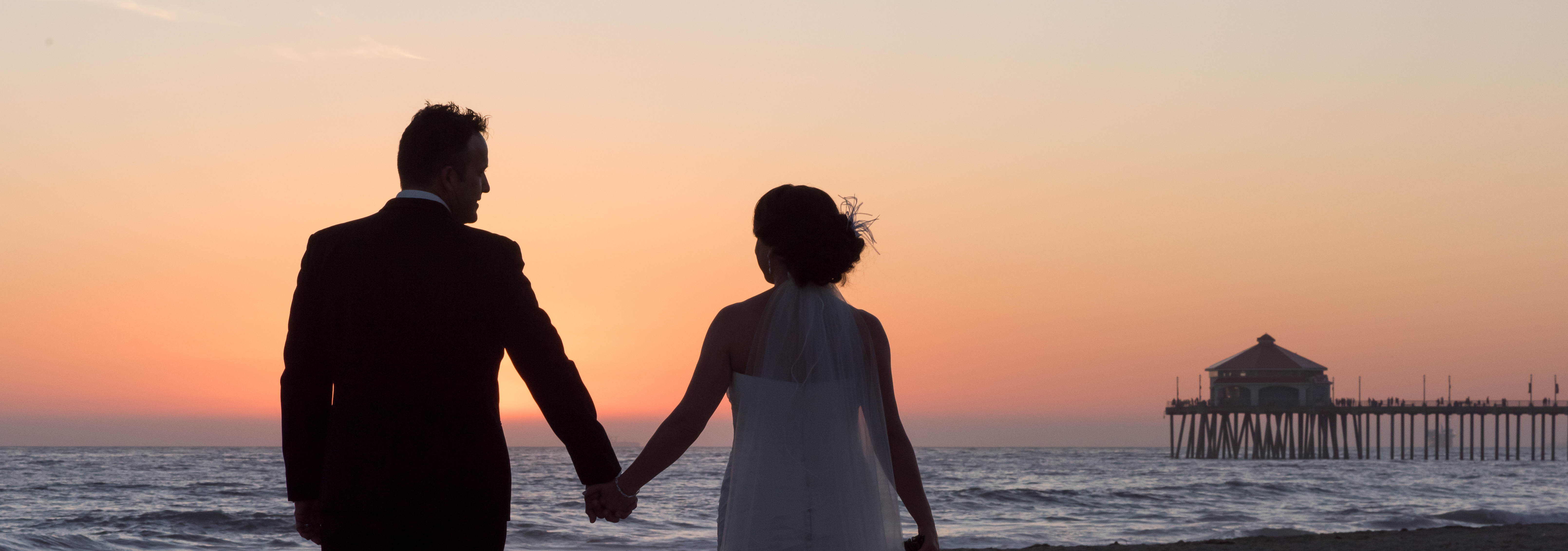 Wedding couple at sunset holding hands in Orange County